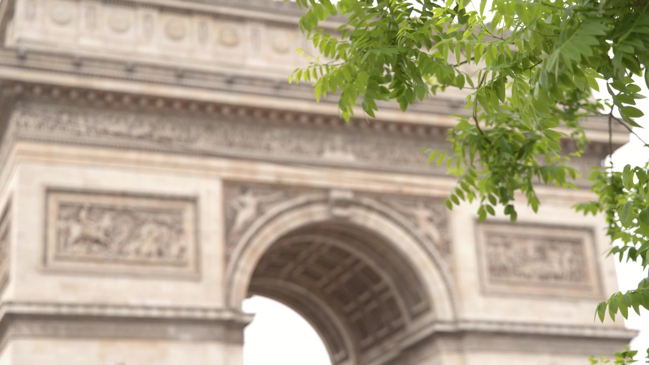 Inquadratura media dell'Arco di Trionfo attraverso un fogliame verde vibrante a Parigi, Francia