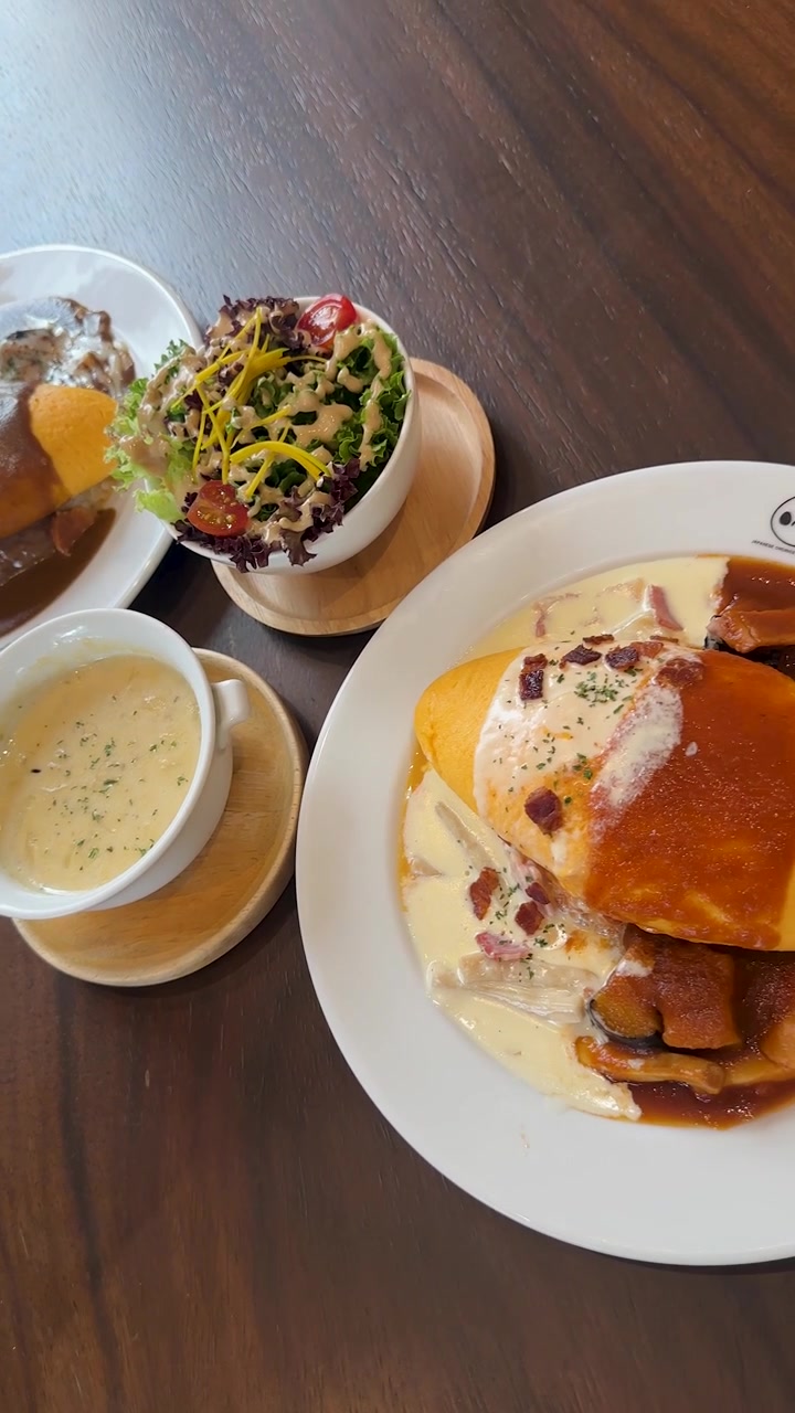 La telecamera panoramica su insalata, zuppa, omelette e riso con salsa cremosa con luce naturale.