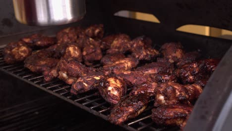 delicious chicken wings on hot grill are basted with bbq sauce