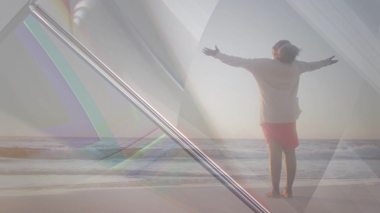 Vídeo vertical: Prisma em movimento mostrando mulher com top claro e saia rosa de frente para o oceano, com os braços estendidos