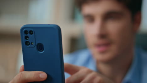 smiling man playing cellphone at morning apartment close up. happy businessman