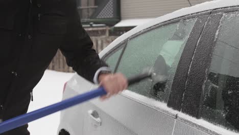 scraping the ice frost forming in the window frame of the car - close up shot