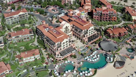 aerial view orbiting luxury cabo holiday resort, over sheraton tilt up to ocean horizon view