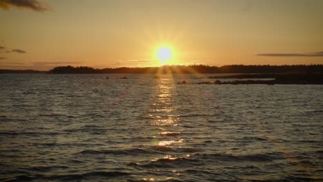 hermosa escena con el sol poniéndose pintando el cielo por encima de las olas rompiendo
