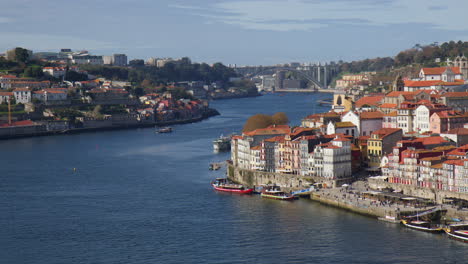 distant view of ponte de arrabida crossing douro river on sunny day in porto, portugal. wide static shot