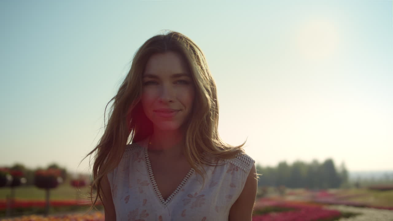 아름다운 여자 얼굴 미소. 예쁜 소녀 꽃 배경에 머리카락을 똑바로.