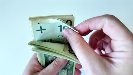 mane hands counting one hundred złoty banknotes