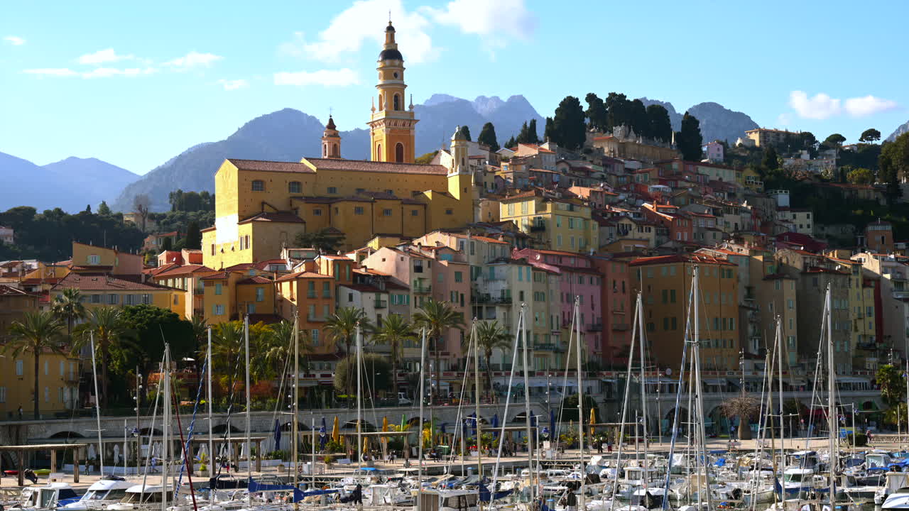 View of boats docked in the Port de Menton in the French Riviera with the colourful buildings on the background, Menton, France