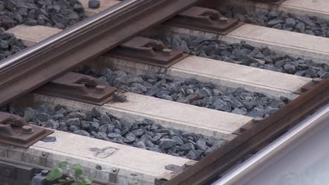 close-up of railway tracks with detailed texture of stones and metal