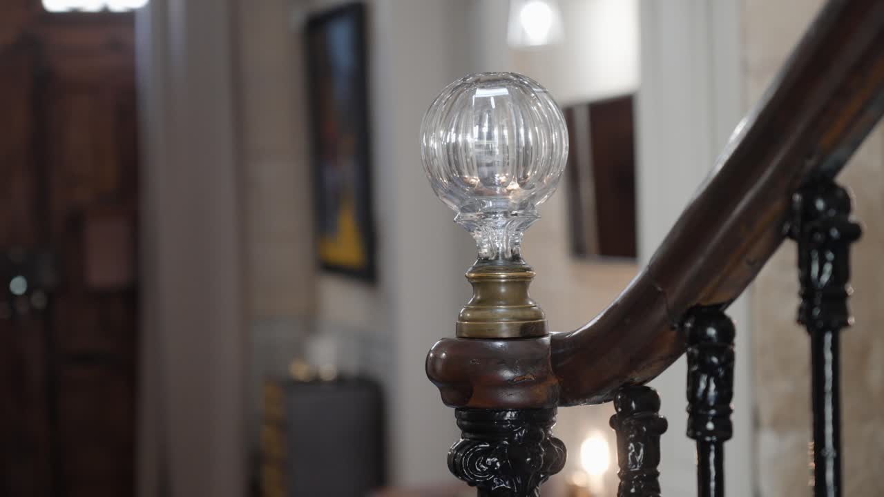 slow establishing shot of a crystal ball on the end of a wooden handrail