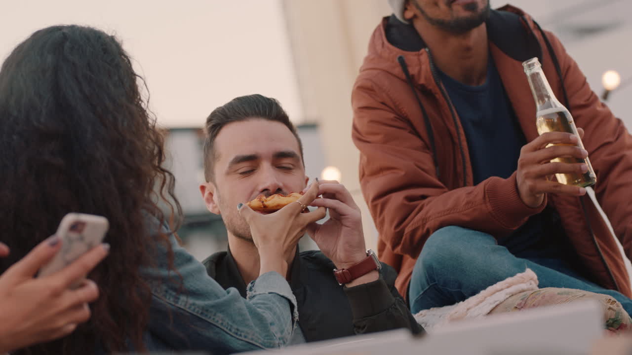 행복한 옥상 파티 친구들이 술을 마시고 주말에 즐겁게 지내고 사회 모임에서 대화하고 피자를 나누고 함께 어울리는 것을 즐기고