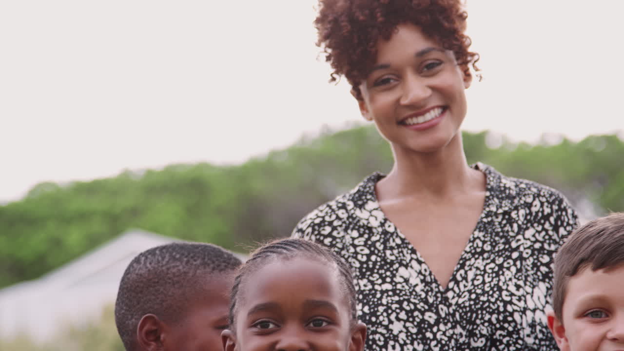 유니폼을 입은 교사가 경기장에서 서 있는 초등학교 학생들의 야외 초상화
