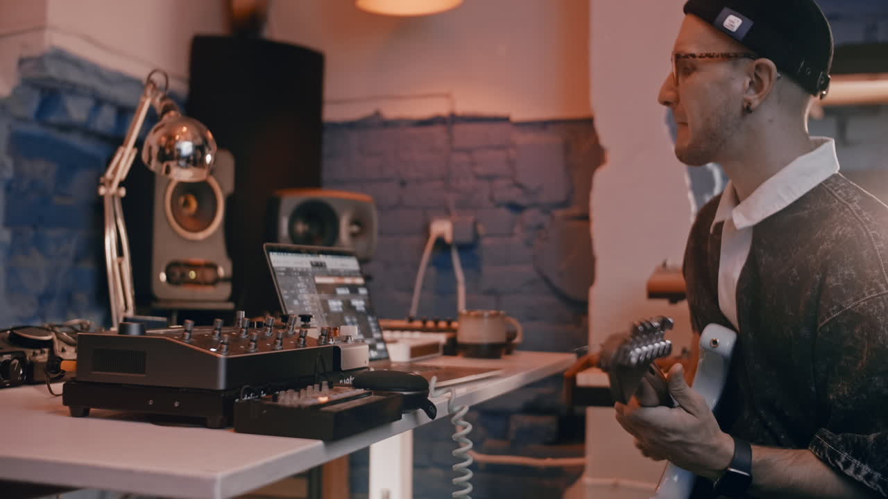 녹음 스튜디오 에서 기타 를 연주 하는 음악가