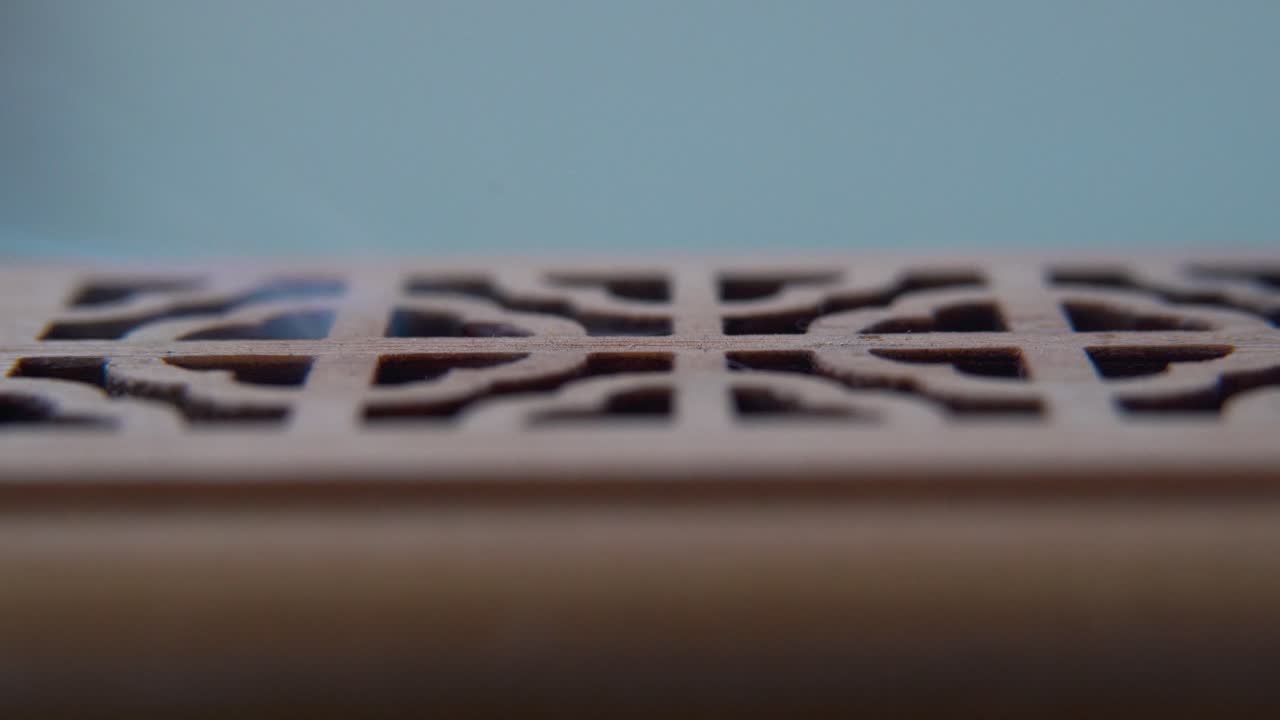 A close-up macro shot of smoking incense in a wooden box, spiritual ritual meditation, scented therapy fragrance, relaxing aromatic white smoke, textured case, smooth cinematic 4K video tilt up
