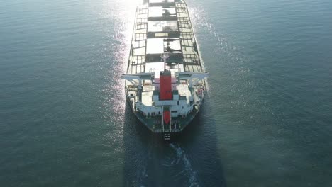 Toma-Aérea-De-Un-Gran-Barco-De-Carbón-Que-Sale-Del-Puerto,-Gladstone,-Queensland,-Australia