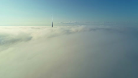 Pico-De-La-Torre-De-Televisión-Por-Encima-De-Las-Nubes-Con-Fondo-De-Cielo-Azul