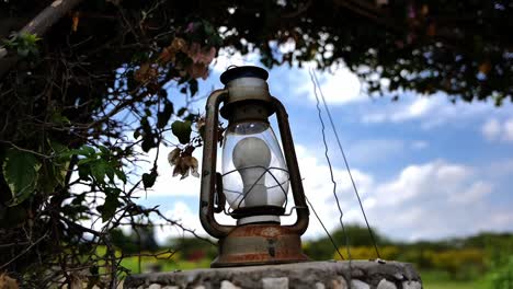 closeup of old and rusty vintage lamp with lightbulb in the garden