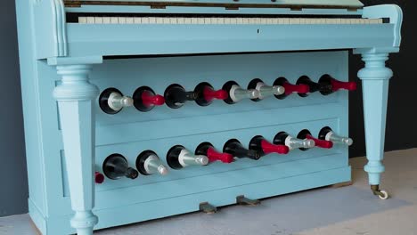 Slow-pan-of-blue-painted-piano-repurposed-to-display-wine-in-restaurant---wine-bar