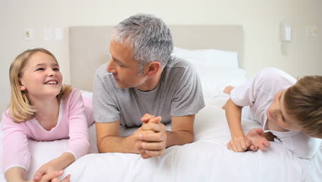 Smiling-children-lying-with-their-father