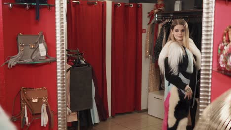 mujer intentando un abrigo de piel en una boutique de moda
