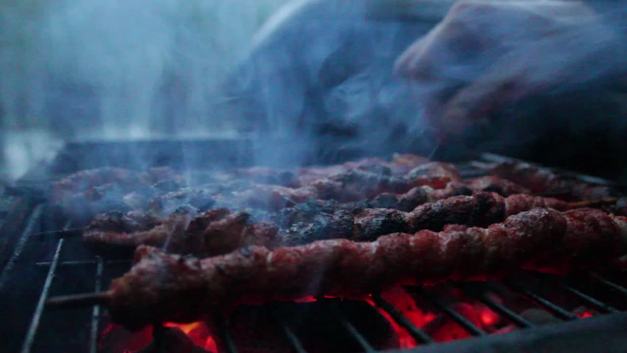 Meat on the grill and someone grabbing it