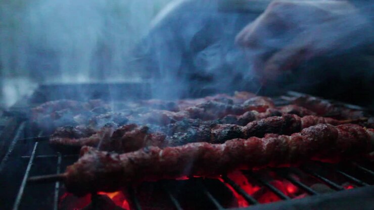 Meat on the grill and someone grabbing it
