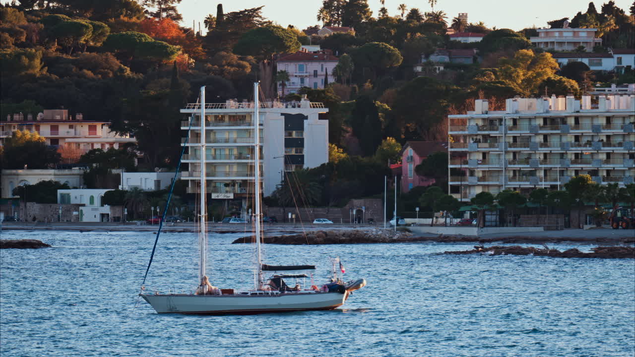 Juan-les-Pins, France - January 25, 2025: Small boat floating on the sea at sunset