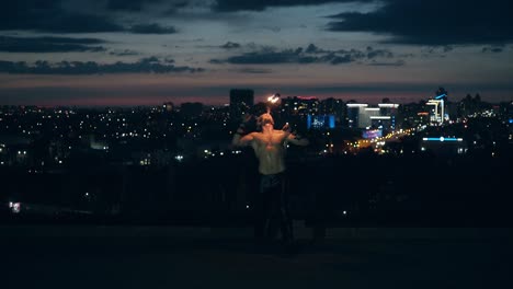 joven hombre rubio hace trucos con fuego hombre se arrodilla mientras respira fuego haciendo bola de fuego