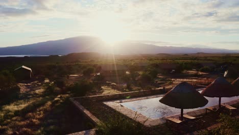 stunning sunset over african desert landscape with luxury lodges and pool