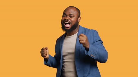 man dancing from happiness, celebrating achievement, studio background