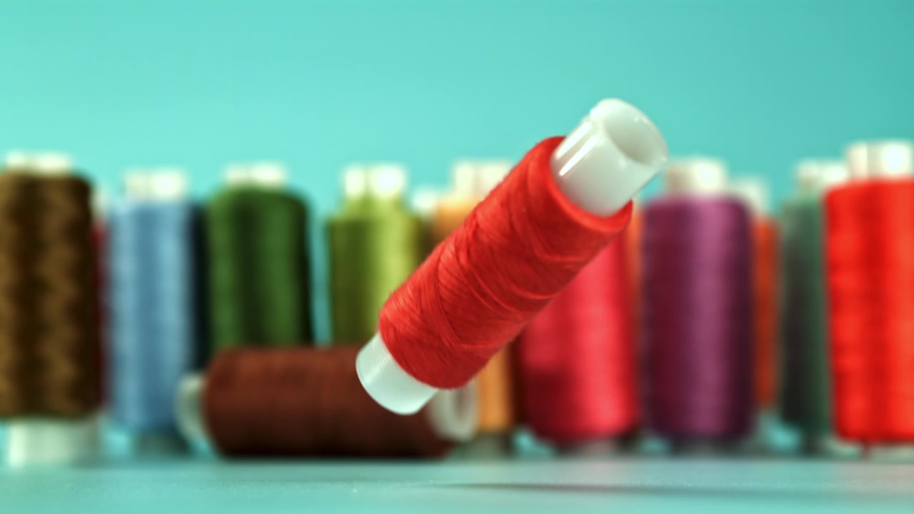 Red Thread Spool Falling and Bouncing in Slow Motion