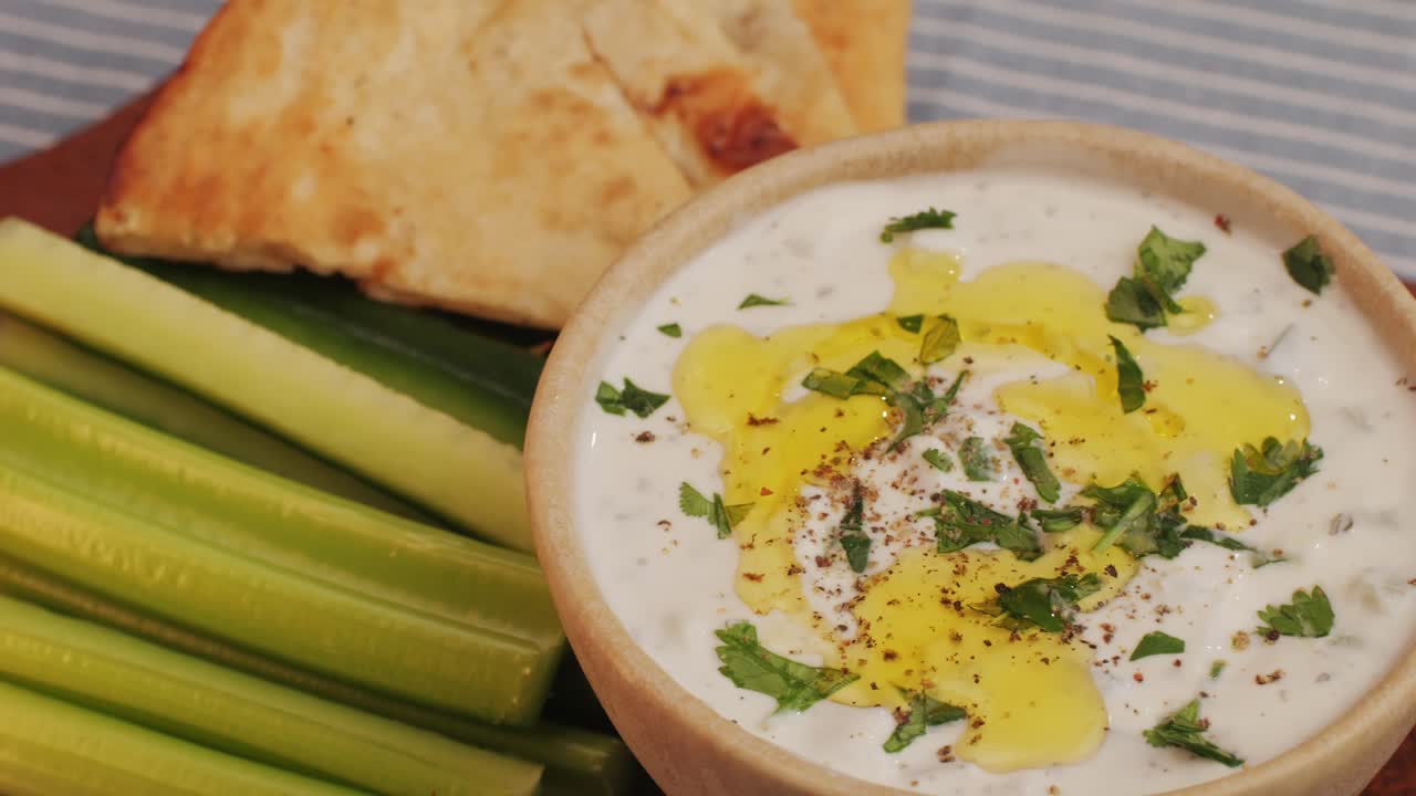 Greek Tzatziki sauce of salted strained yogurt or diluted yogurt mixed with cucumbers and mint, garlic, salt, olive oil on top. High quality 4k footage