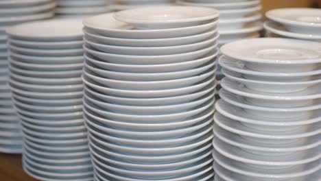 stacks of white saucers and plates