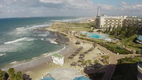 4k aerial - rocky coastline with crashing waves dolly in pan up - north israel