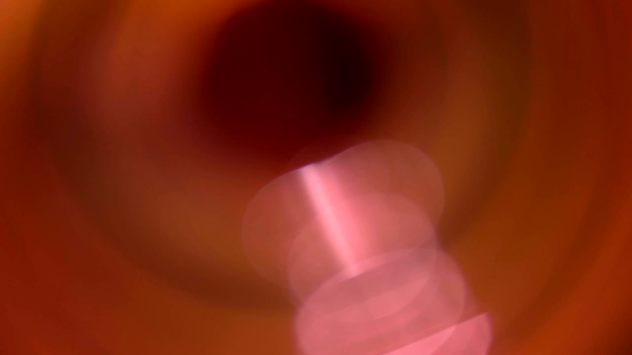 la aparición de un flash desenfocado y resaltos de luz naranja en un fondo negro en movimiento 4k