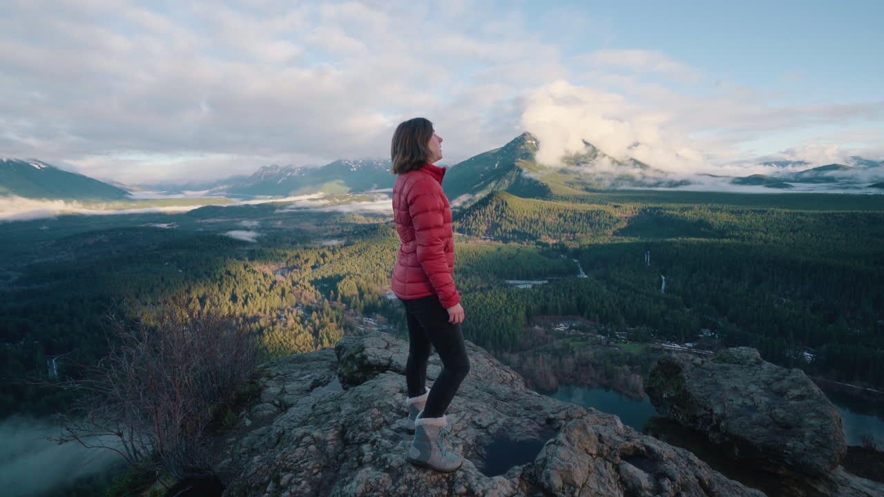Girl hiking up to rocky vantage point overlooking in Washington State