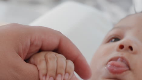 close up mother holding baby hand touching fingers mom nurturing newborn caring for infant at home motherhood love 4k