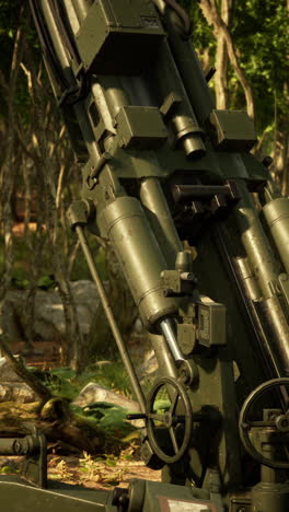 closeup of a green military artillery cannon in a forest