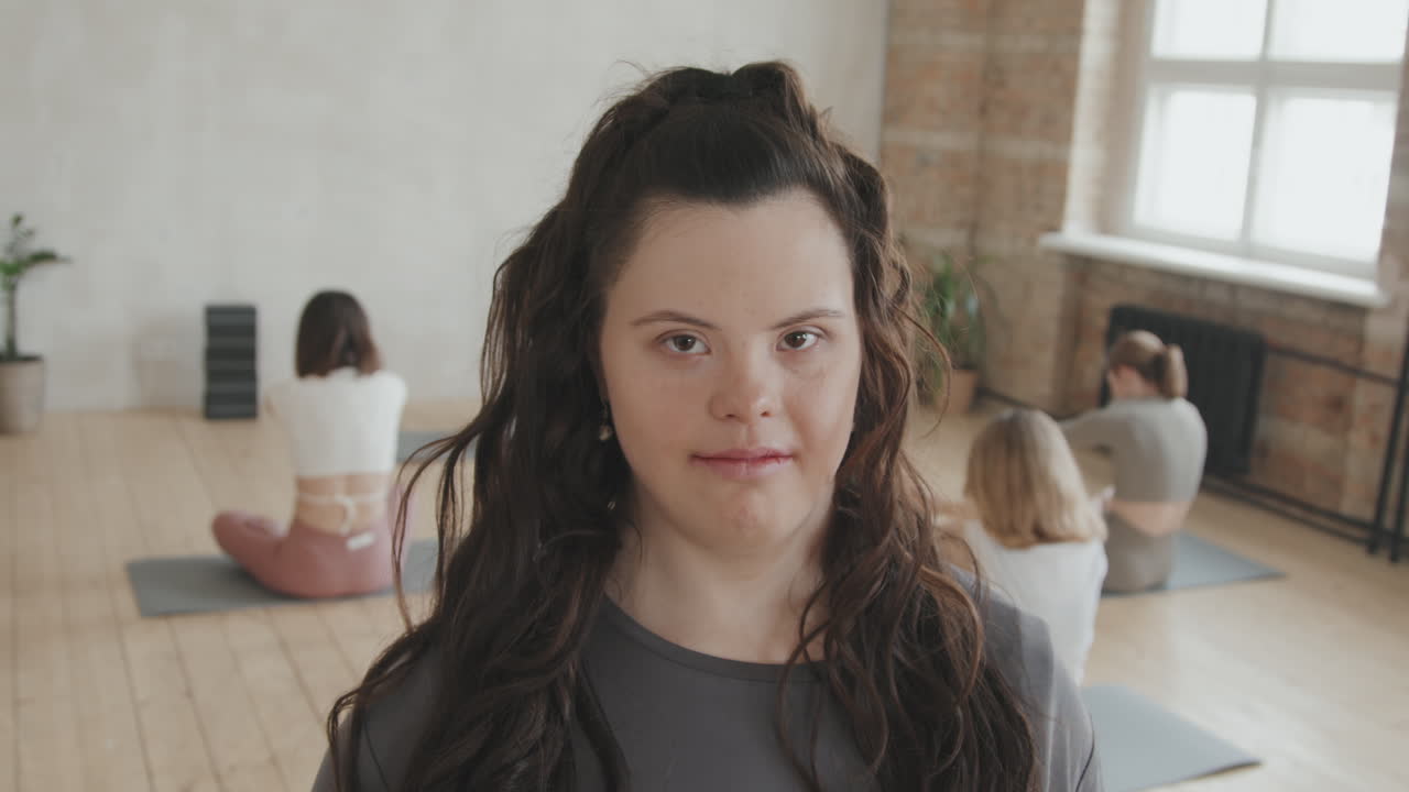 Portrait Of Young Smiling Woman With Down Syndrome In Yoga Class