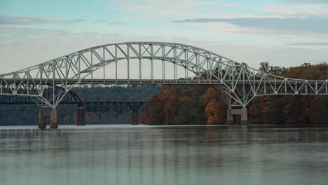 Zeitraffer-Von-Wolken,-Die-über-Zwei-Brücken-Ziehen,-Mit-Vorbeifahrendem-Verkehr-Und-Vorbeifahrenden-Booten-Auf-Dem-Wasser-Des-Chesapeake-Bay-Susquehanna-River