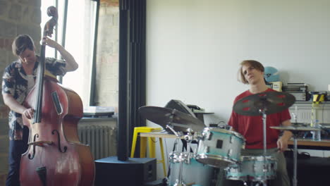 a musical duo rehearsing with a drummer and an upright bassist
