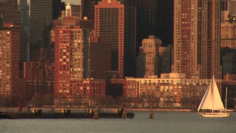 a sailboat heads toward the pier off downtown manhattan