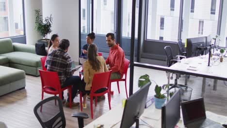 grupo diverso de colegas de negocios sentados en sillas discutiendo
