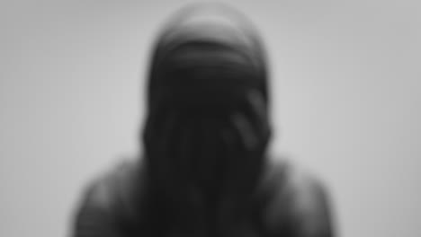a mummified woman against the bright background in keeps her hands on her face the powerful pose full of despair