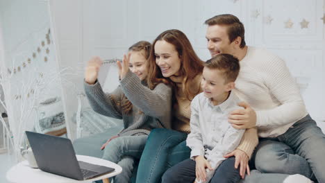 Familia-Sonriente-Charlando-En-Una-Computadora-Portátil-En-La-Sala-De-Estar