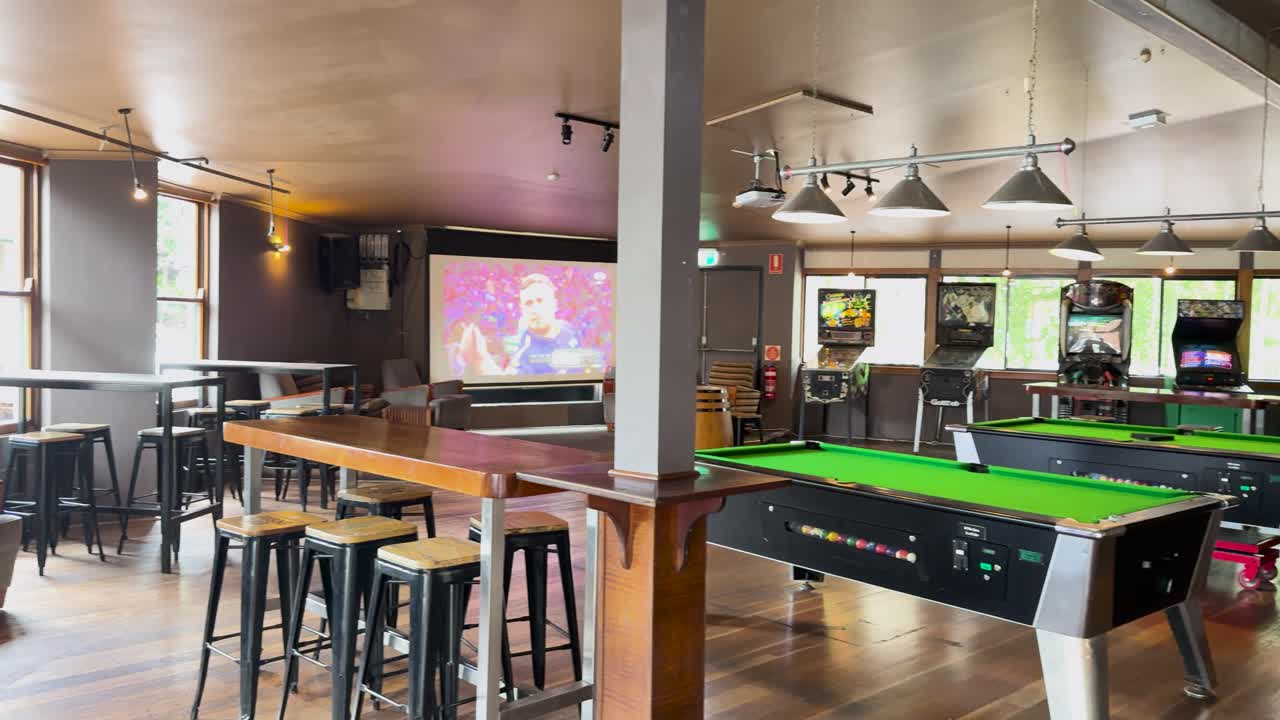 Empty gaming room with pool tables and screens