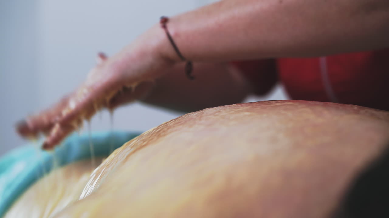 un especialista experto hace masajes con miel de la espalda de la mujer