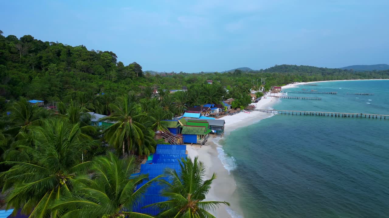 colorful bungalows rising on a tropical beach in Koh Rong island, Cambodia. Amazing aerial view flight fly reverse drone