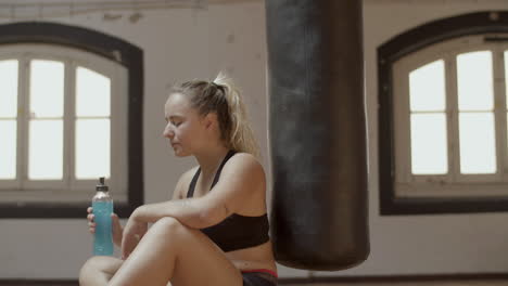 side view of athletic woman drinking isotonic in gym