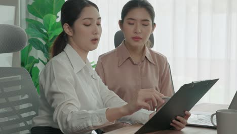 Two-young-enthusiastic-businesswoman-working-together-in-the-office-workspace.